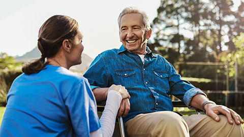 young female nurse outside with a senior patient in a wheelchair