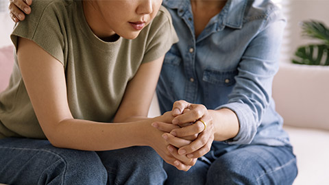 a woman offering comfort to a young lady