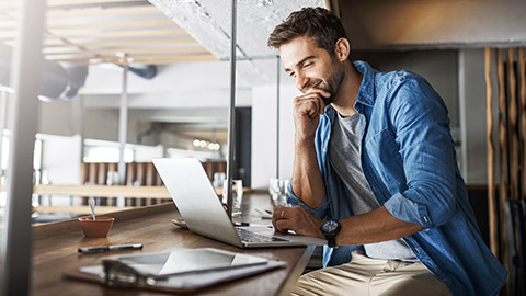 Man in coffee shop, laptop and small business owner