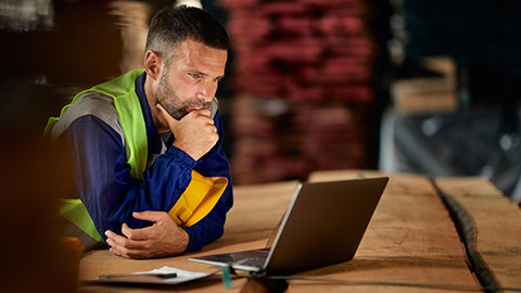 A construction manager reading information on a laptop