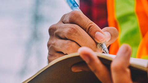 A close view of a person writing on a notebook