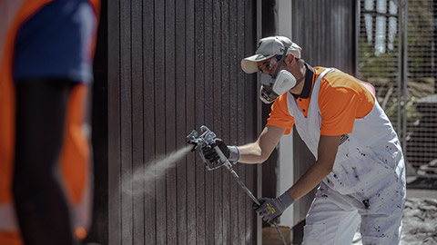 A construction worker spraying something on a site