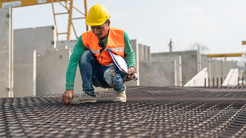 A person inspecting building supplies on a site