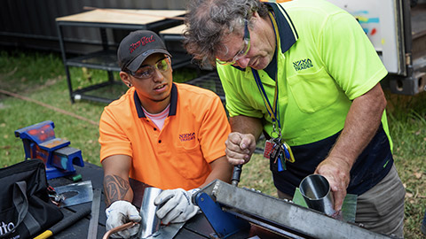 Boss showing apprentice a skill