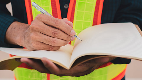 A close view of a supervisor writing notes