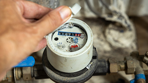 A person reading a water meter