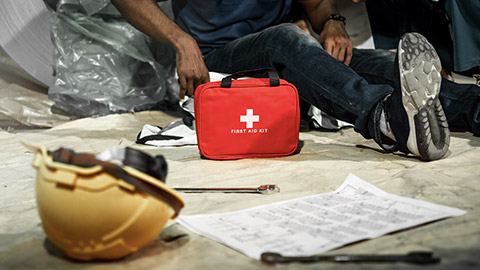 Emergency staff with first aid kit helping a man