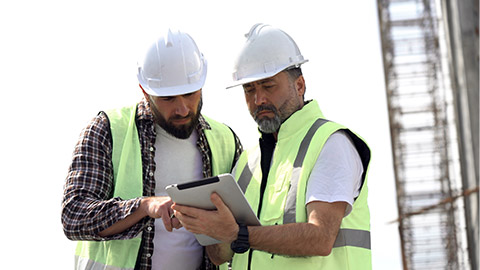 Building workers looking at tablet