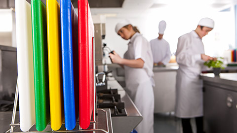 A variety of coloured plastic cutting boards in a kitchen