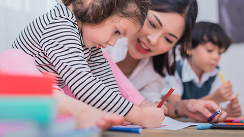 A close view of a child drawing on paper