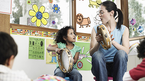 A teacher and a maori student playing and singing