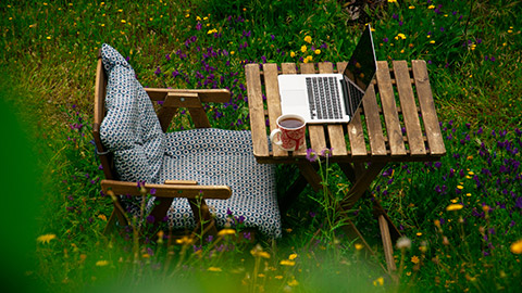 A desk and laptop in a garden