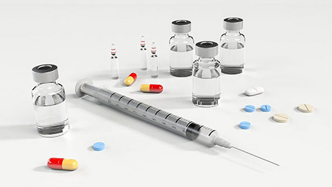 A shot of syringe and pills