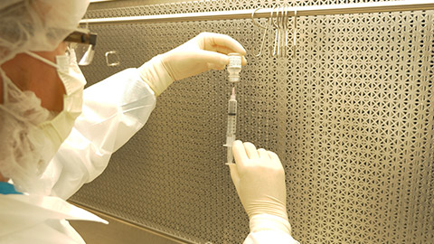 A pharmacist drawing fluid out of a vial