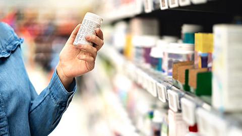 A person reading a medicine label