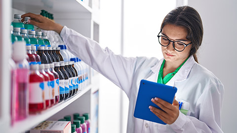 A pharmacist grabbing medicine from a shelf