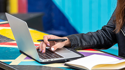 A close view of a person studying with a laptop