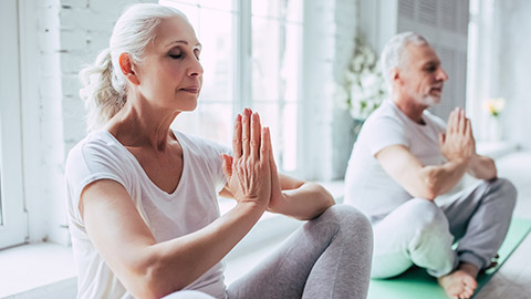 2 mature aged people doing yoga