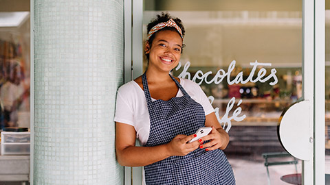 A small business owner in front of their shop