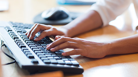 A person typing on a keyboard