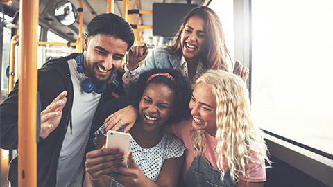 A group of friends laughing together on a bus