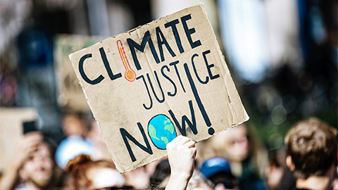 A person holding up a sign for climate change at a protest