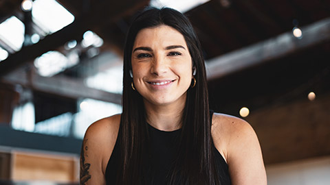 A medium shot of a smiling youth worker sitting in a modern office space