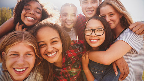 A group of diverse youth smiling and posing for the camera