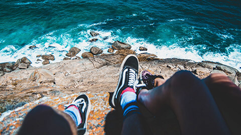 Teenagers sitting overlooking the ocean