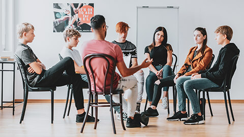 A mentor talking to a group of teenagers