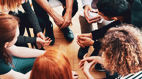 Top down view of a group of teens talking about an activity