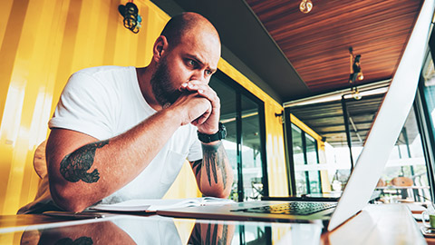 A youth worker contemplating data on a laptop screen