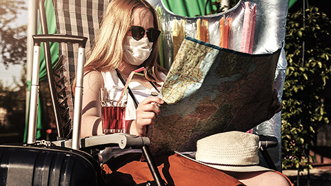 A person in a cafe reading a map with a mask on