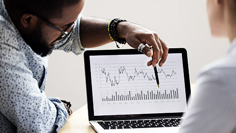 Focused analyst showing colleague annual financial report analyzing business data