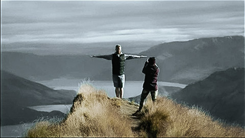 Man photographing his companion on top of a hill