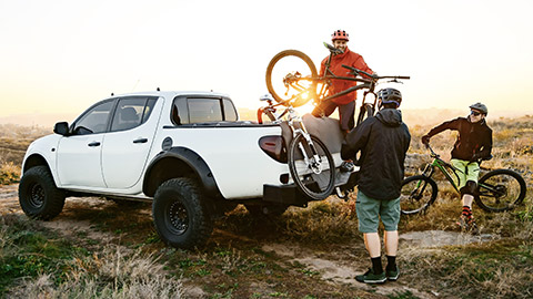 Cyclist unloading bikes from 4x4 vehicle