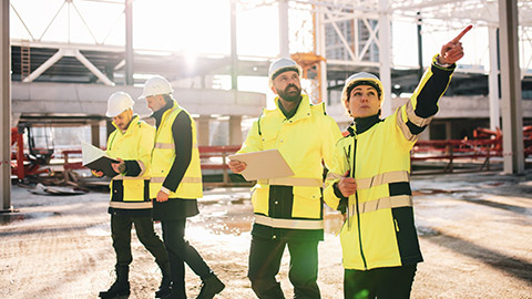 Workers on building site pointing at something