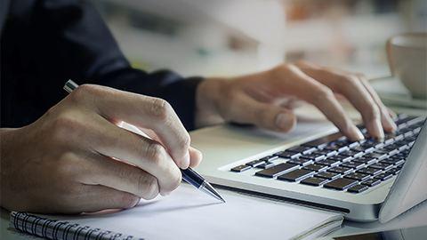 businessman hand working with new modern computer and writing on the notepad for strategy diagram as concept