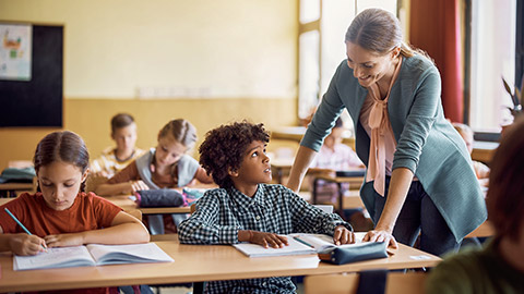 teacher assisting her student during a class at elementary school