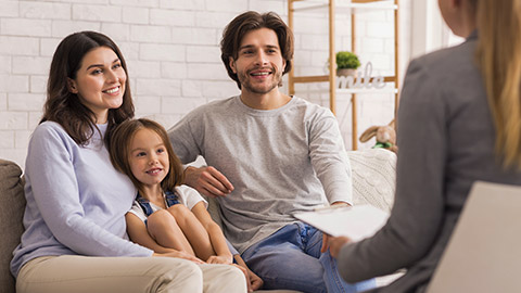 Parents With Little Daughter Sitting Together communicating with a teacher