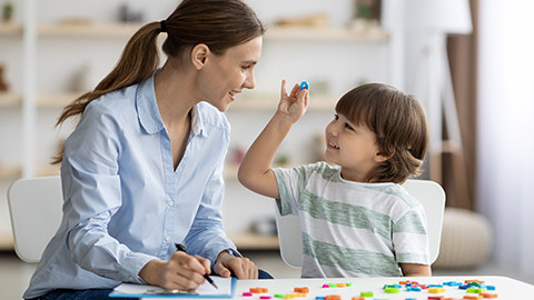 boy showing and pronouncing sound O with his teacher, exercising together at classroom