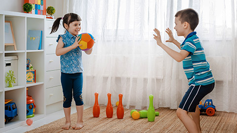 children boy and a girl play in a children's game room, throwing ball