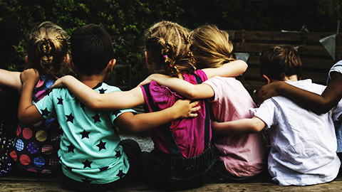 a group of children with arms around each others shoulders