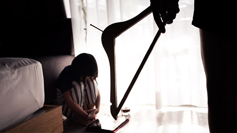 an adult threatening to hurt a child with a hanger