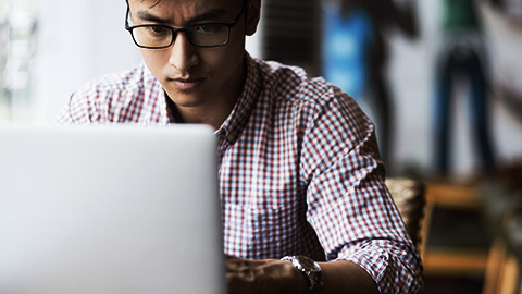 a person seriously typing in a laptop