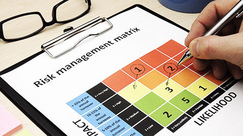 A person checking off in the risk matrix