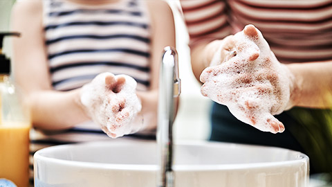 A teacher showing how to wash hands to child