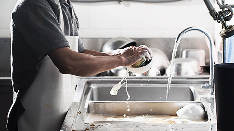 A person cleaning used dishes