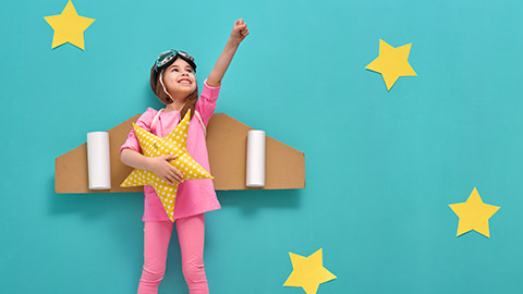 Little child girl in an astronaut costume is playing and dreaming of becoming a spaceman