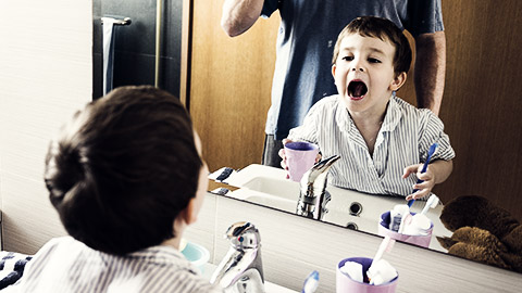 A child being taught how to brush teeth